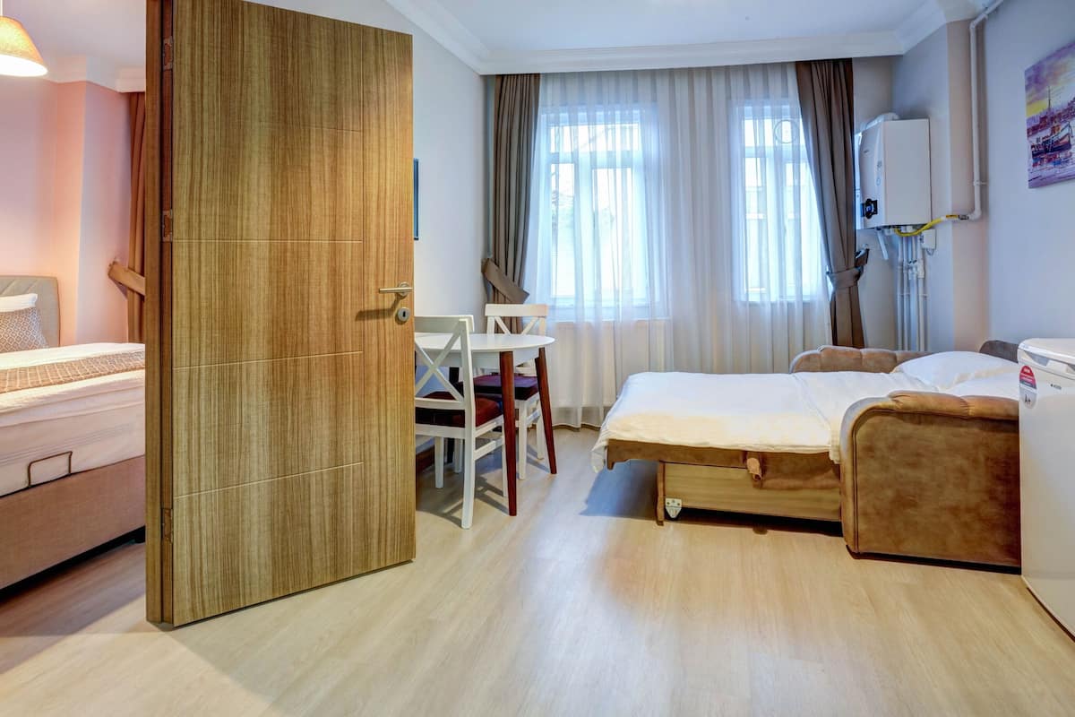 Quarto de hotel com cama, escrivaninha e cadeira.