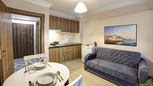 A compact living space with a dining area, kitchenette, and a sofa. - Seven Roses Apart Hotel (Istanbul)
