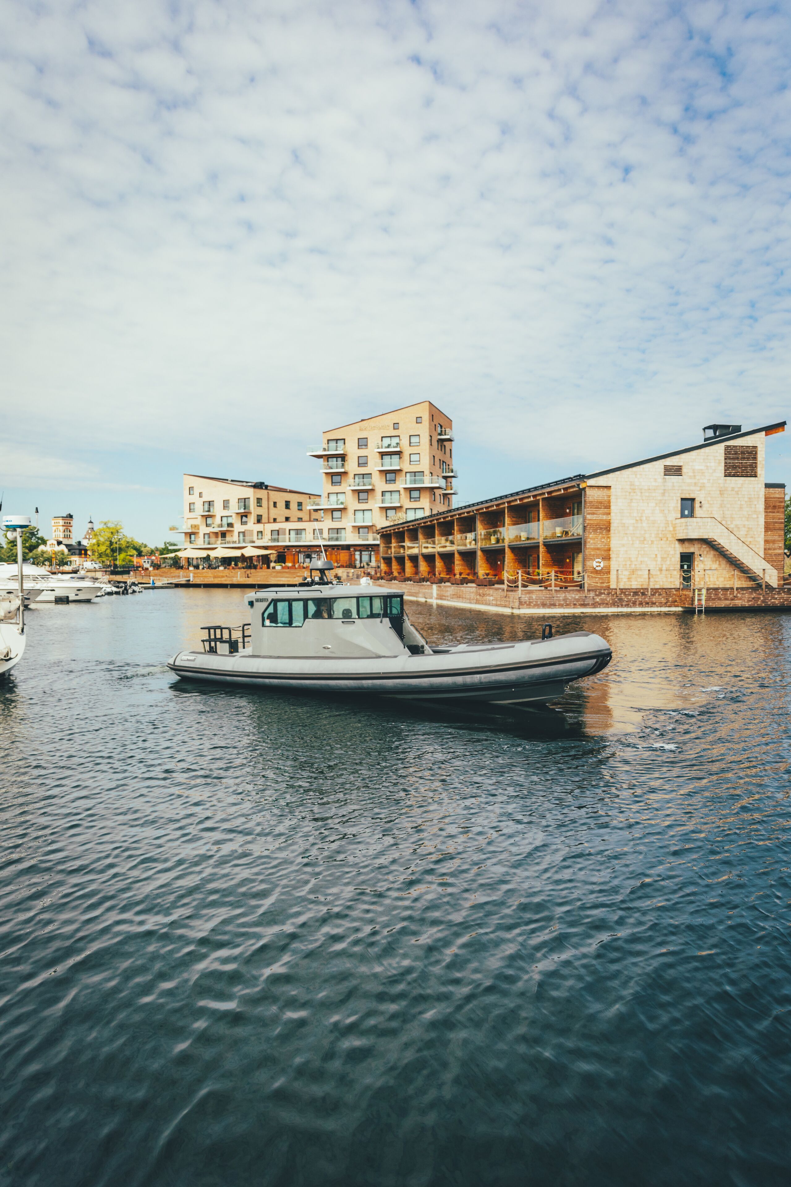 A boat docked at a marina with a building in the background.