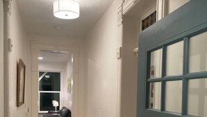 A hallway with a blue door, white walls, and a tiled floor. - The Cottage-Historical Home Valley Views! (S) (Ogden)