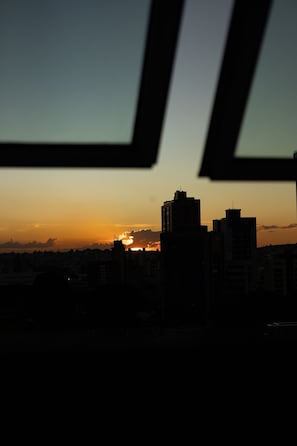 Silueta del horizonte urbano al atardecer, con edificios y un cielo despejado.