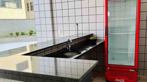 Une cuisine moderne avec un plan de travail noir, un évier et un réfrigérateur rouge à l’effigie de Coca-Cola.