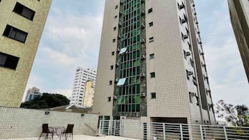 A high-rise building with a swimming pool and outdoor seating area.