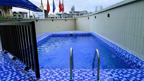 A swimming pool with blue mosaic tiles and metal railings, surrounded by a beige wall. - Alicia Hotel (Douala)