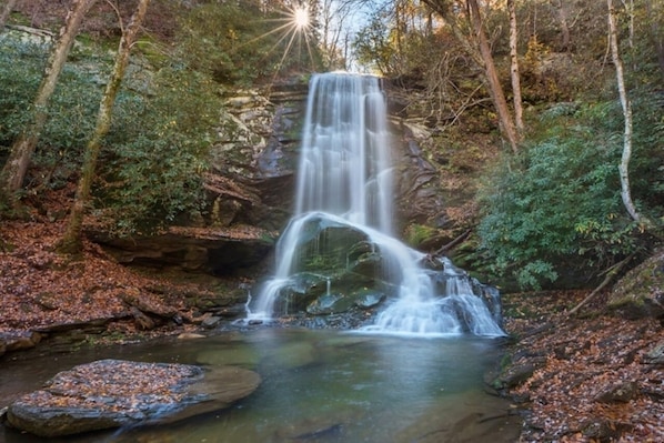 A waterfall in a forested area with a clear stream at the base. - Fireside Retreat | Pet-Friendly, Hot Tub, Game Area & Fire Pit! (Black Mountain)