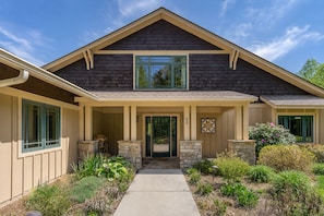 A two-story house with a front porch, stone pillars, and a number '22' on the door.