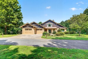 A two-story house with a garage, a front porch, and a well-maintained lawn.