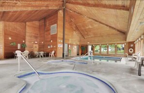 A wooden cabin with a pool area, including a hot tub and a standard pool.