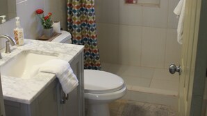 A bathroom with a toilet, sink, and shower area. - Soleil de la Palms (St. Ann's Bay)
