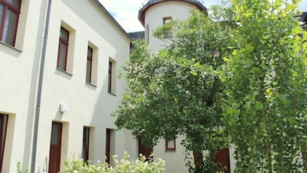 Ein Gebäude mit einem runden Turm und zahlreichen Fenstern.