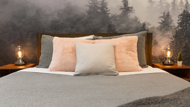 A bed with a grey blanket and pillows, two bedside tables with lamps, and a forest view through a misty window. - Washington State Inspired, Free Parking (Bellevue)