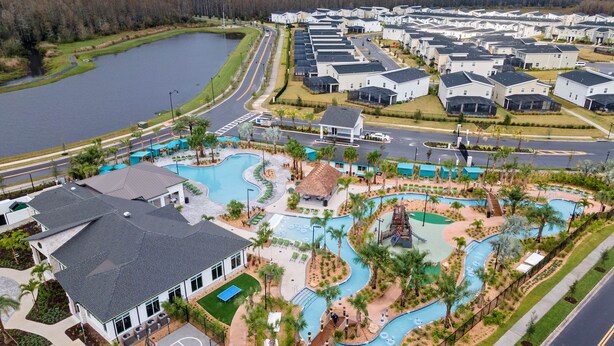 An aerial view of a residential area with a large swimming pool, a basketball court, and a road with a curve. - 🍂 Fall Special! Bliss Pool Villa Close to Disney & Universal; Great Clubhouse🏝️ (Kissimmee)