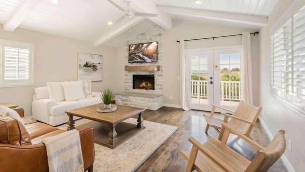 A spacious living room with a fireplace, white furniture, and a balcony with white shutters. - Hakuna Moscato - 30 day Wine Country Retreat (Temecula)