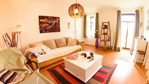 Una sala de estar acogedora con un sofá, una mesa de centro y una alfombra colorida.