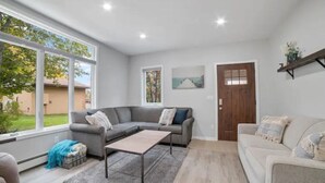 Ein modernes Wohnzimmer mit einer Eckcouch, einem Couchtisch und Blick ins Freie.