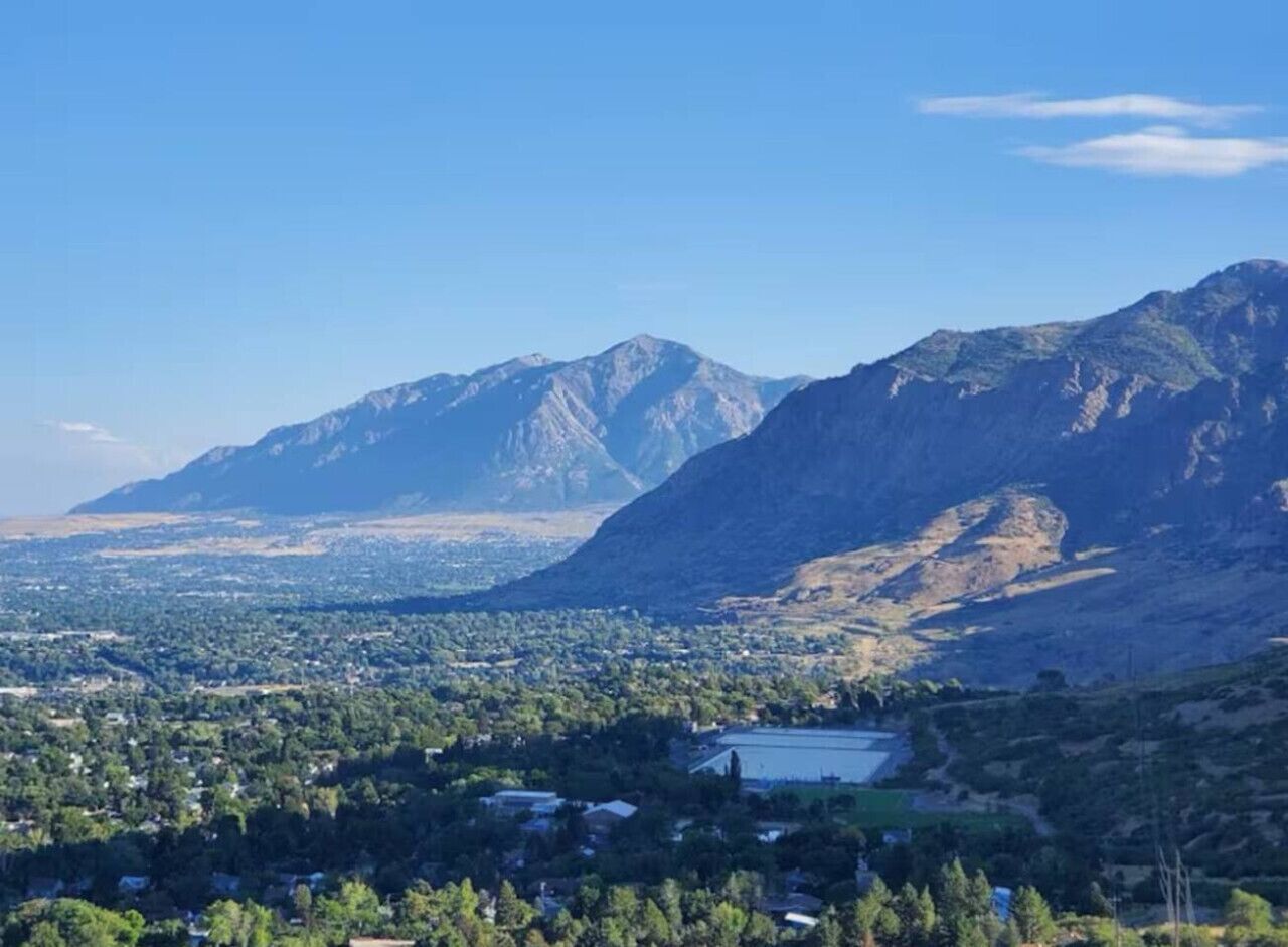 Un paisaje montañoso con un pueblo en el valle.