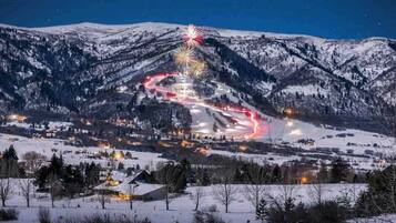 A snow-covered mountain landscape with a ski resort and a ski lift.