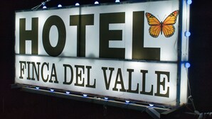 En hotellskylt med namnet ”HOTEL FINCA DEL VALLE” och en bild av en fjäril.