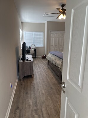 A bedroom with a bed, a desk with a computer, a chair, and a ceiling fan. - Awesome St George Island Home, Walk to Beach! PET FRIENDLY (St George Island)