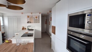 A modern kitchen with a central island, built-in oven, and a TV mounted on the wall. - Roof terrace apartment on the sea waterfront air conditioning wifi (Saint-Raphaël)