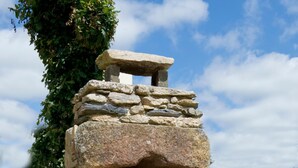 A stone-built outdoor oven with a flat top, surrounded by greenery and a clear sky. - House 8 pers + 1 baby - PMR access - in Monts d'Arrée. (Pets welcome!) (Brennilis)