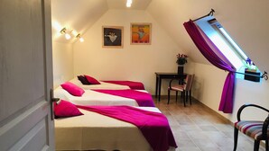 A room with three beds, each with a pink blanket, a desk with a chair, and a window with purple curtains. - House 8 pers + 1 baby - PMR access - in Monts d'Arrée. (Pets welcome!) (Brennilis)