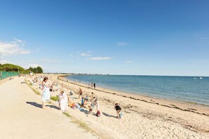 A beach with people sunbathing and walking along the shore. - gite with swimming pool and beach  (Le Tour-du-Parc)