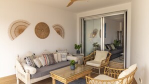 A modern living room with a sofa, two chairs, a coffee table, and decorative wall art. - Serena Apartment with Terrace and Golf View (motril)