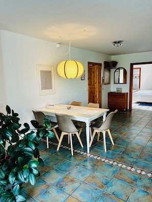 A dining area with a table, chairs, a hanging light fixture, and a potted plant. - Bright, spacious vacation apartment in Schwedeneck/Surendorf, 1 km to the beach (Schwedeneck)