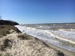 A beach with waves crashing onto the shore, sandy terrain, and a clear sky. - Bright, spacious vacation apartment in Schwedeneck/Surendorf, 1 km to the beach (Schwedeneck)