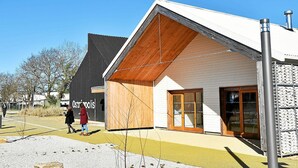 A modern building with a sloped roof and large glass doors, labeled "Ostrópolis." - Nice cottage with swimming pool, 5 min from the beach, called "STIBIDEN". (Le Tour-du-Parc)