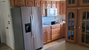 A kitchen with wooden cabinets, a stainless steel refrigerator, and a ceiling fan. - Nice home for rent in a quiet area close to Scottsdale and Glendale  area.  Open (Sun City)