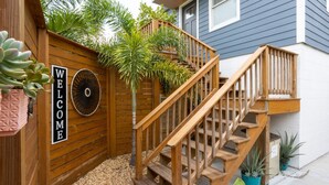 Een houten terras met een houten trap naar een huis.