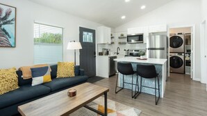 Een modern appartement met een woonkamer, keuken en wasruimte.
