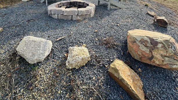 A modern outdoor seating area with Adirondack chairs and a stone fire pit, surrounded by large rocks and gravel. - 
Secluded Mountain Container - Hot Tub & King Bed (Hatfield)