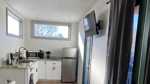 A compact kitchen with a microwave, refrigerator, and a window above the sink. - 
Secluded Mountain Container - Hot Tub & King Bed (Hatfield)