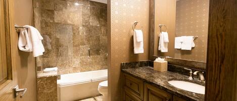 A bathroom with a bathtub, toilet, and sink.