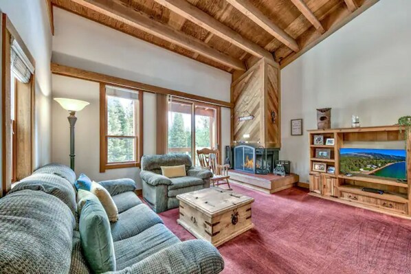 Una sala de estar acogedora con chimenea, asientos cómodos y televisor.
