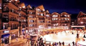 A multi-story hotel with balconies and a central courtyard with a fountain. - Northstar Resort 2BR 2BA Condo. Forest Views. Pools, Pickleball, Trails & More (Truckee)
