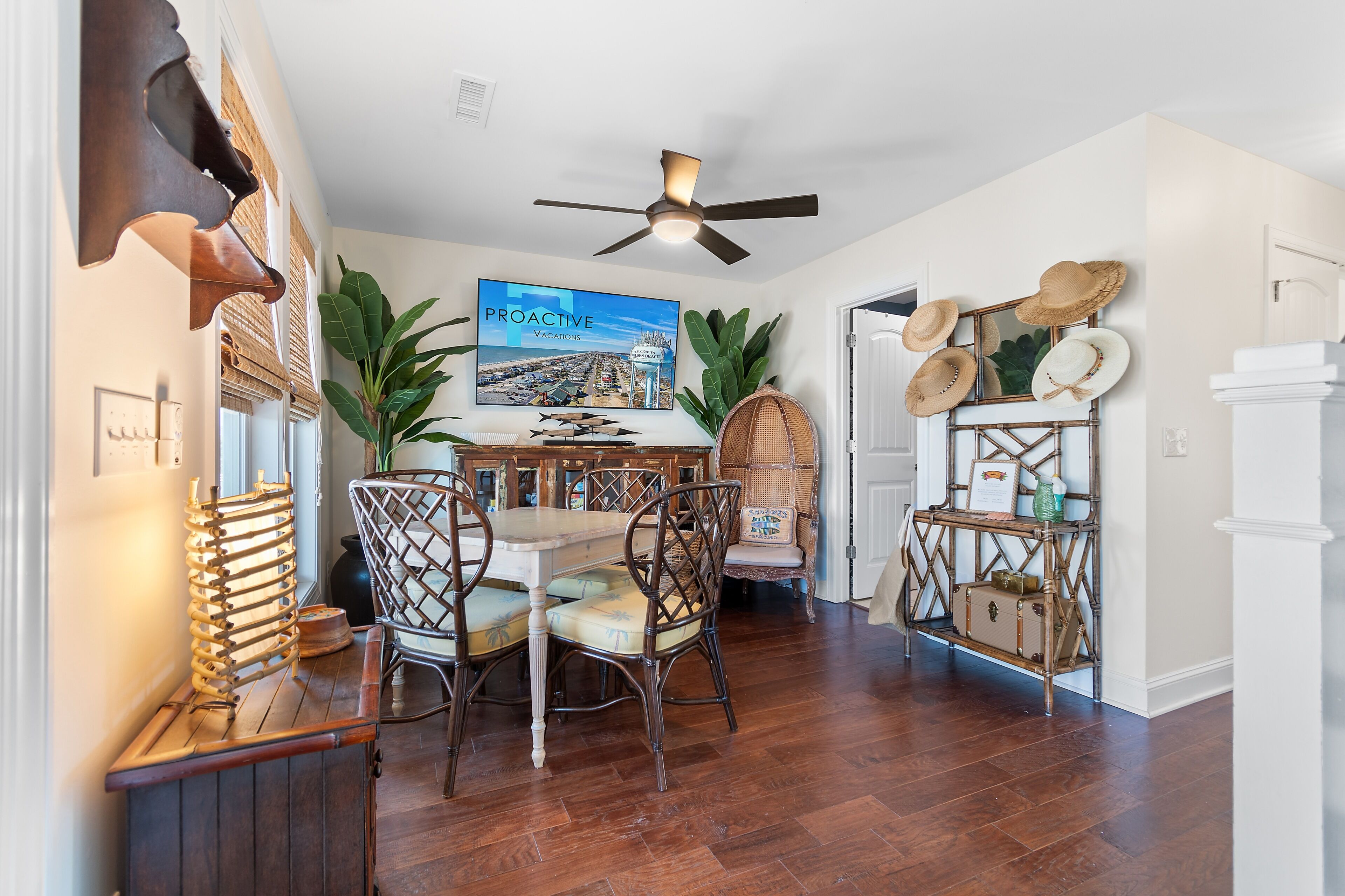 A dining area with a table, chairs, and a ceiling fan.