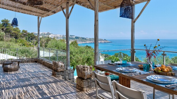 A terrace with a table set for dining, overlooking a coastal view. - Villa Soleluna 7+1, Emma Villas (Marina di Marittima)
