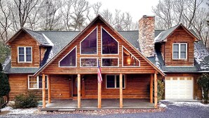 A log cabin with a stone chimney, a garage, and a front porch. - Rustic Log Cabin By Bryce Resort XL Game Room Fire Pit Pets Friendly & More (Mount Jackson)