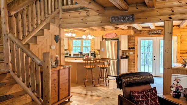 A wooden cabin interior with a staircase, a kitchen area, and a bar. - Rustic Log Cabin By Bryce Resort XL Game Room Fire Pit Pets Friendly & More (Mount Jackson)