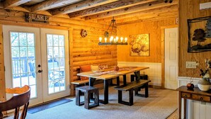 A cozy log cabin interior with a dining area, wooden walls, and a chandelier. - Rustic Log Cabin By Bryce Resort XL Game Room Fire Pit Pets Friendly & More (Mount Jackson)