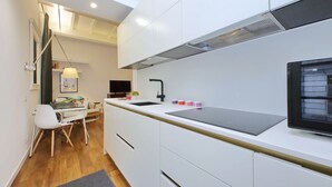 Een moderne keuken met witte kastjes, een zwart aanrecht en een inbouwoven.