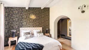 Un dormitorio con una cama grande, una mesita de noche, una lámpara y un espejo.