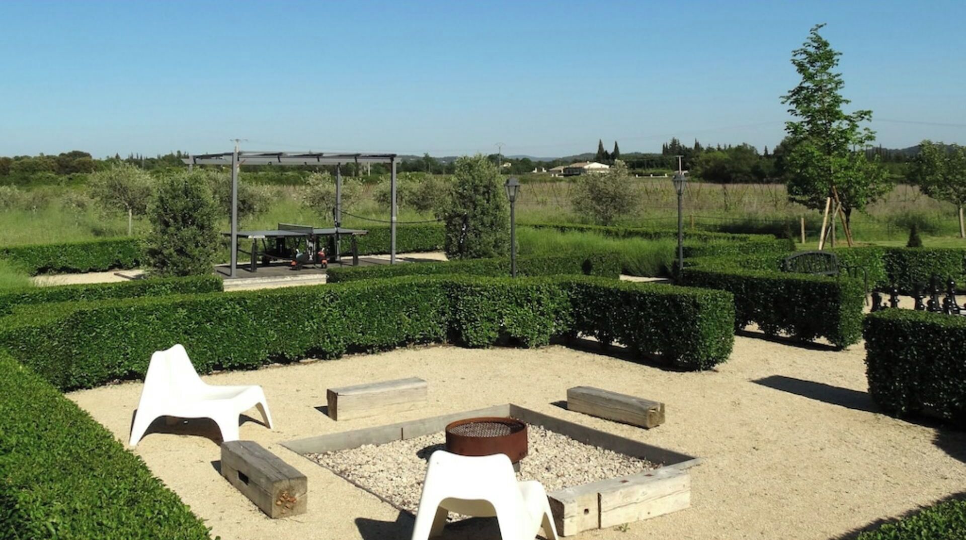 A garden with a fire pit, seating, and a pergola.
