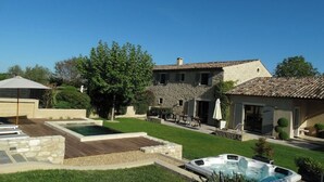 Una casa grande con piscina, zona de estar exterior y jacuzzi.