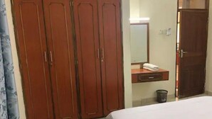 Ein Schlafzimmer mit großem Kleiderschrank, Nachttisch mit Spiegel und einem Bett.