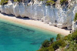 Un paisaje costero con acantilados blancos y una playa arenosa.